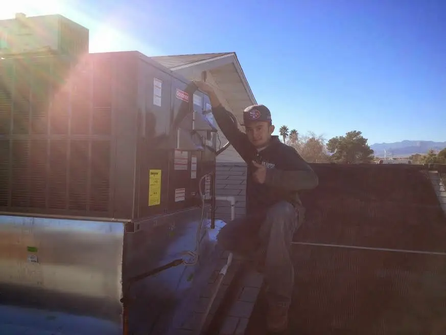 HVAC technician performing Air Duct Cleaning on a rooftop unit in Eaton